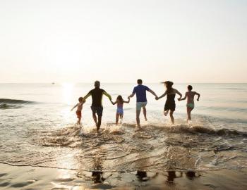 family running into water at the beach