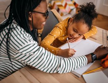 mom and daughter at the table doing schoolwork