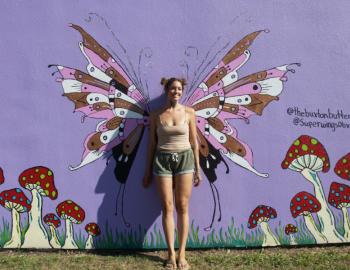 Artist Kennedy Fletcher stand amidst one of her butterfly murals. Artist Kennedy Fletcher stand amidst one of her butterfly murals.