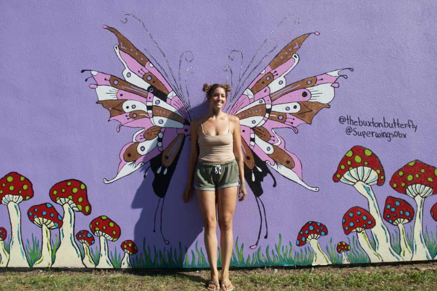 Artist Kennedy Fletcher stand amidst one of her butterfly murals. Artist Kennedy Fletcher stand amidst one of her butterfly murals.