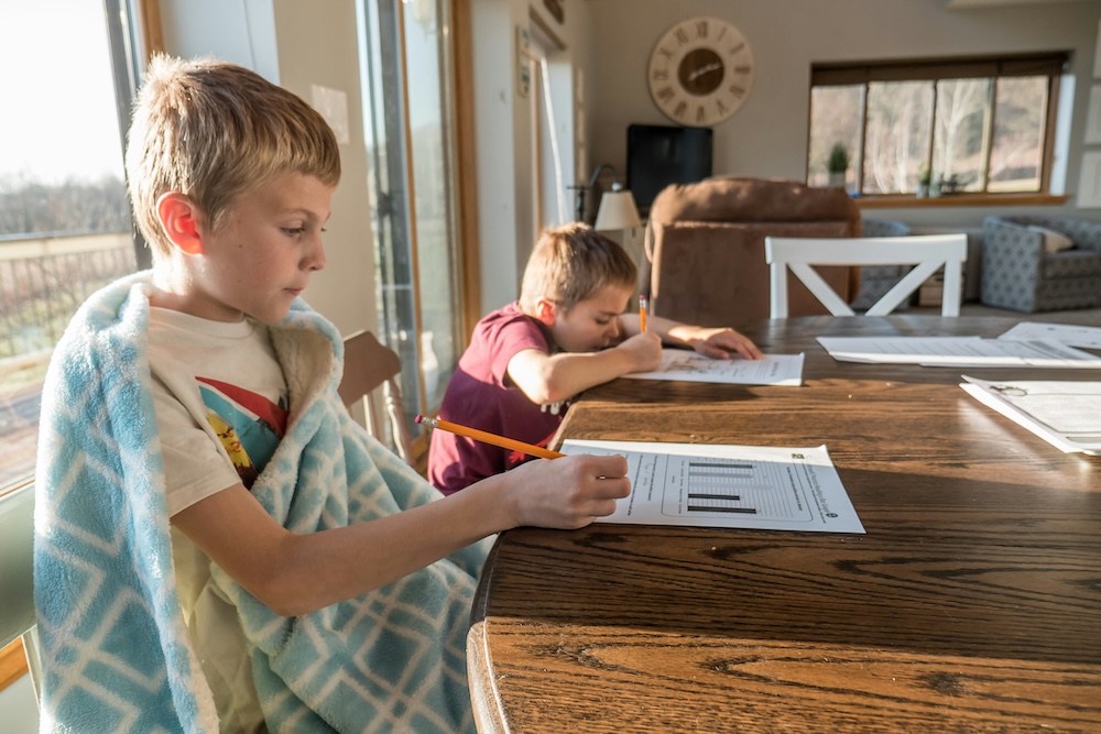 boys sitting at table doing homework